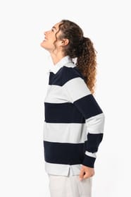 Jeune femme bouclée cheveux attachés qui porte un polo de rugby rayé blanc et bleu marine.
