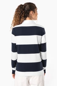 Jeune femme bouclée cheveux attachés qui porte un polo de rugby rayé blanc et bleu marine.
