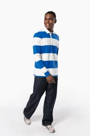 Homme brun qui porte un polo rugby rayé bleu et blanc. 