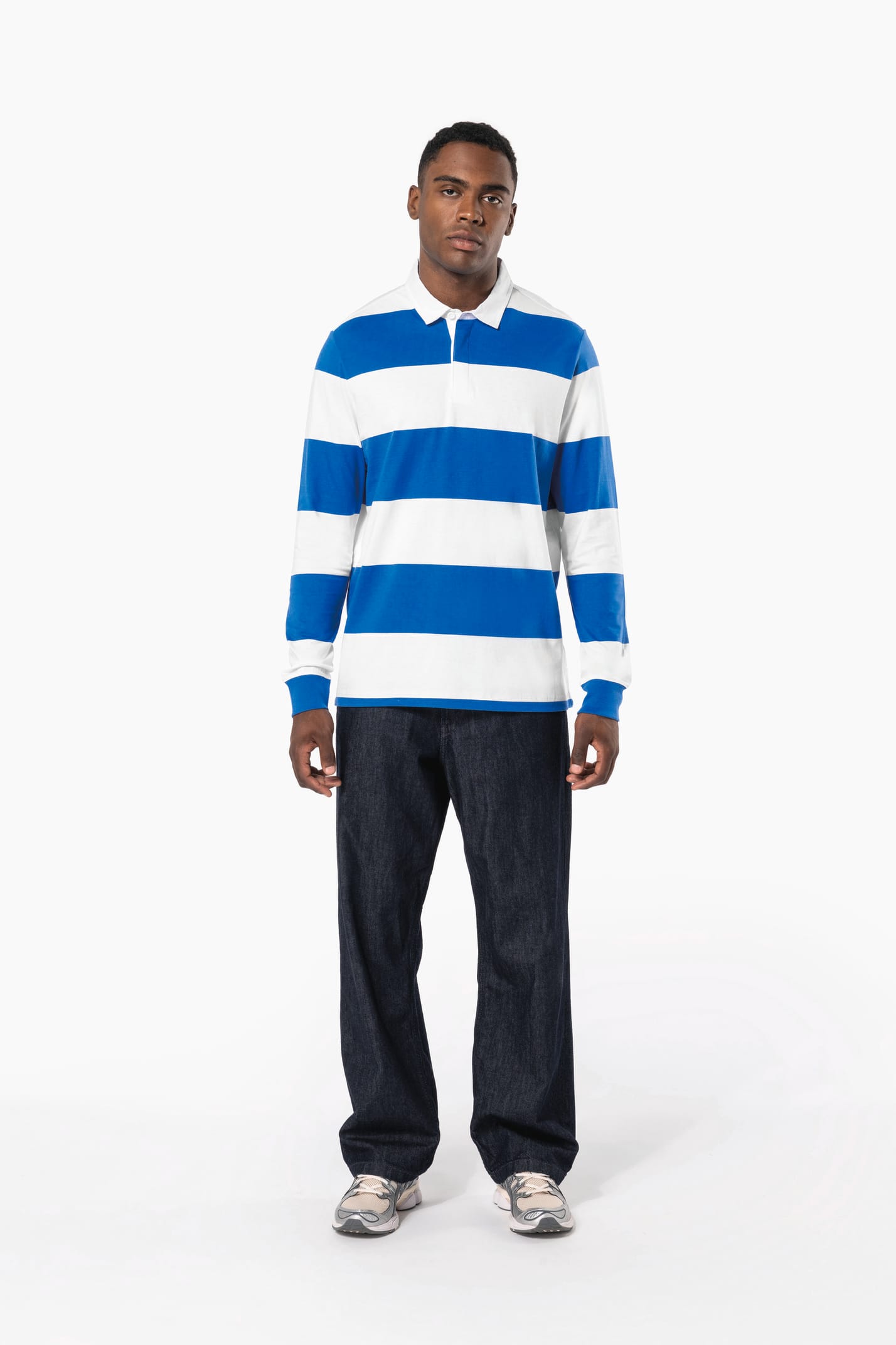 Homme brun qui porte un polo rugby rayé bleu et blanc. 