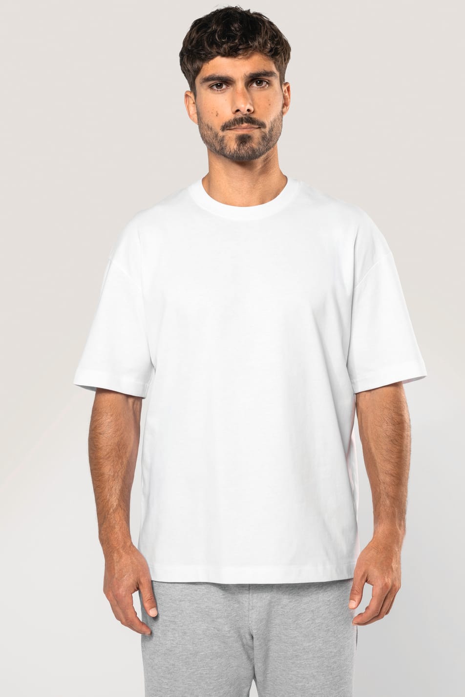 Homme portant un t-shirt unisexe oversize à manches courtes blanc, en coton.