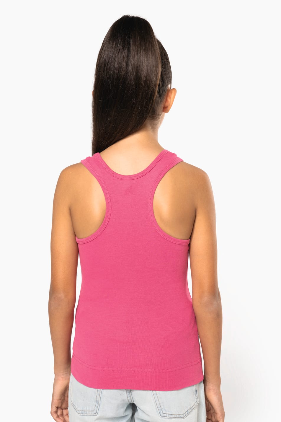 Fillette brune cheveux attachés qui porte un débardeur Fuchsia.