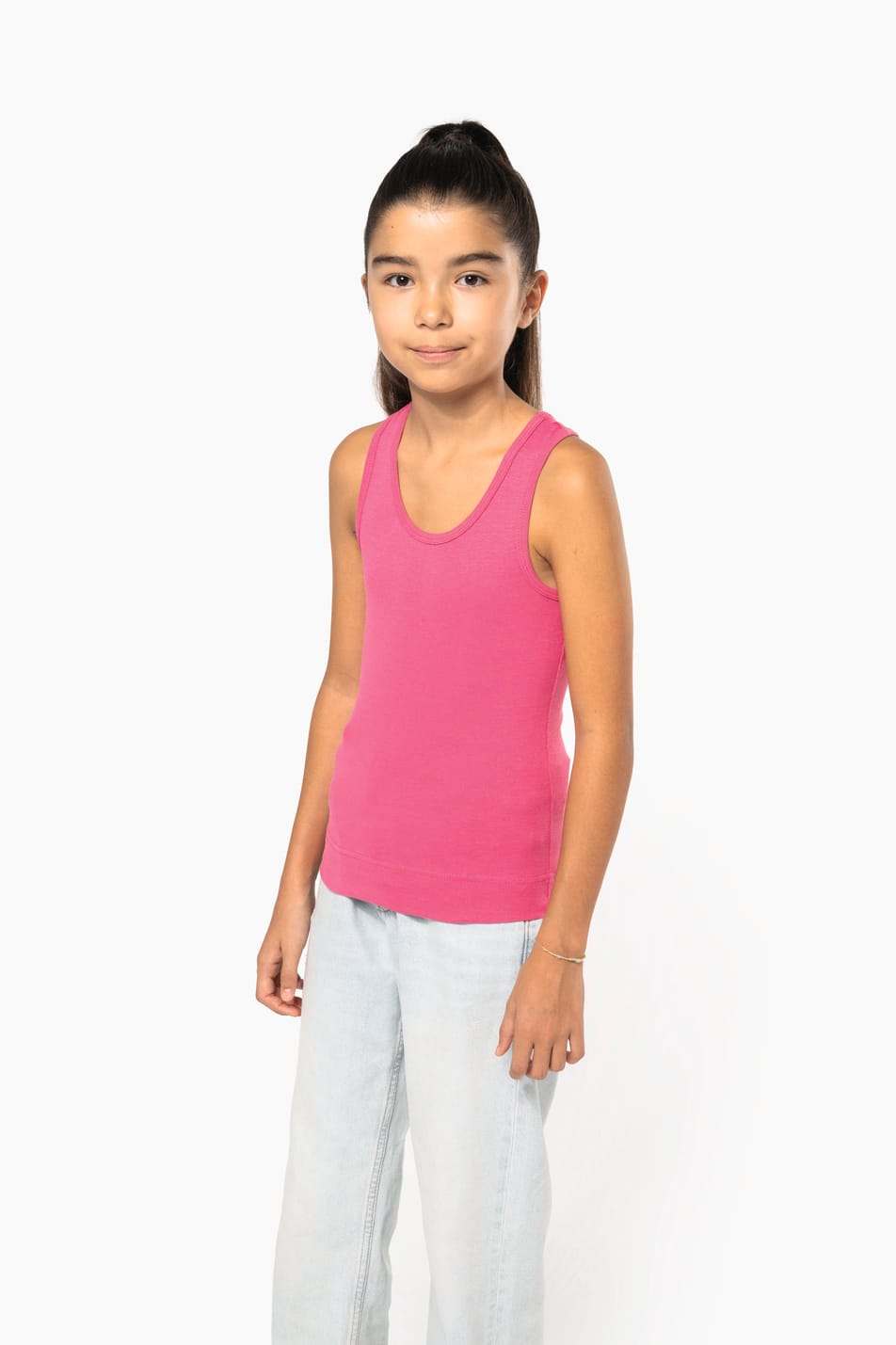 Fillette brune cheveux attachés qui porte un débardeur Fuchsia.