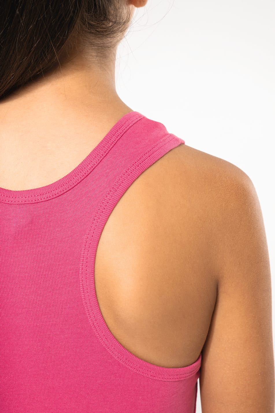 Fillette brune cheveux attachés qui porte un débardeur Fuchsia.