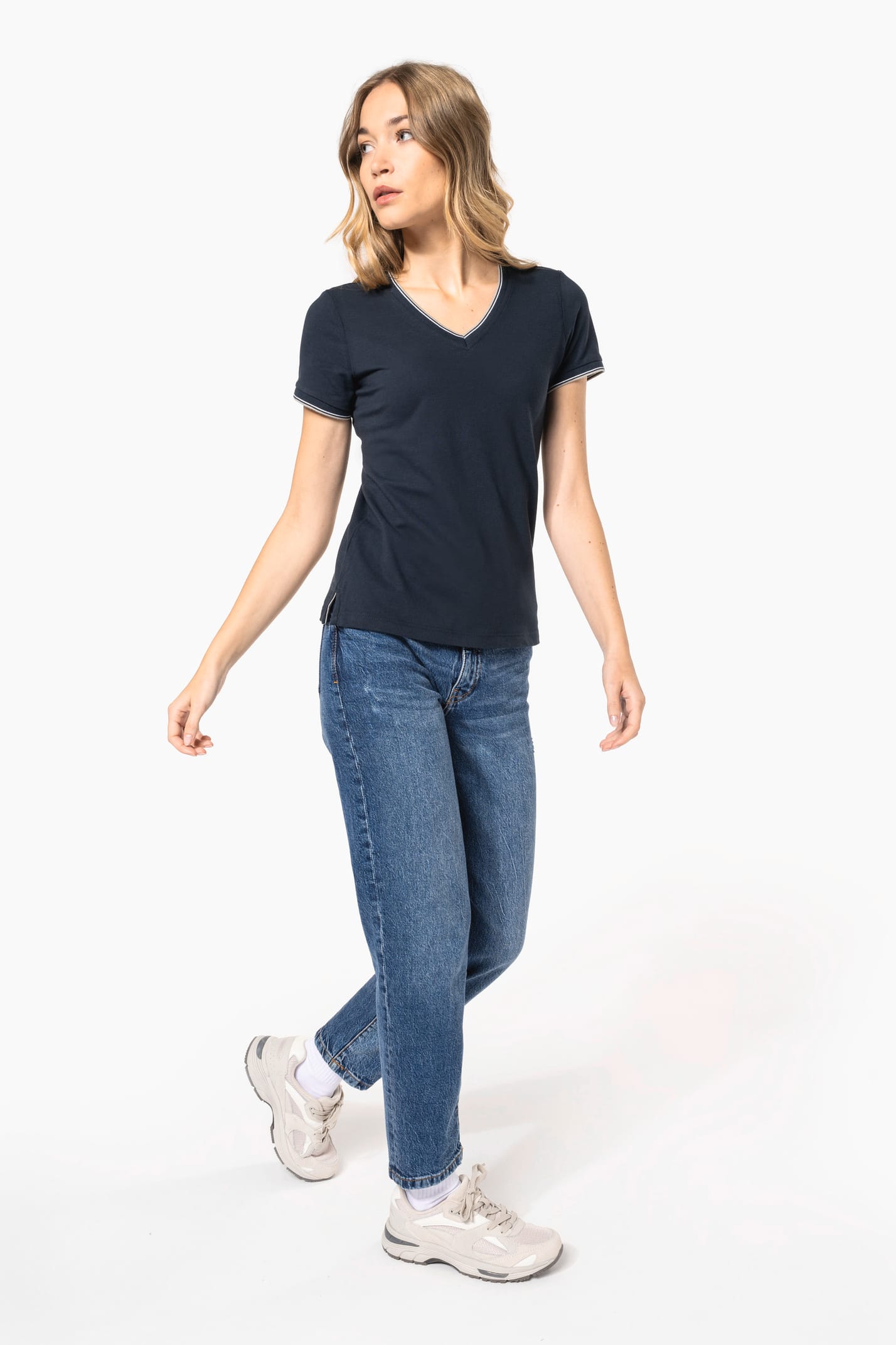 Femme blonde cheveux longs qui porte un T-shirt maille piquée col V Navy.