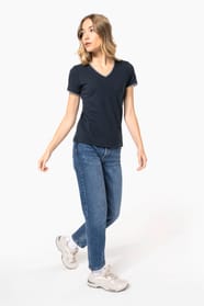 Femme blonde cheveux longs qui porte un T-shirt maille piquée col V Navy.