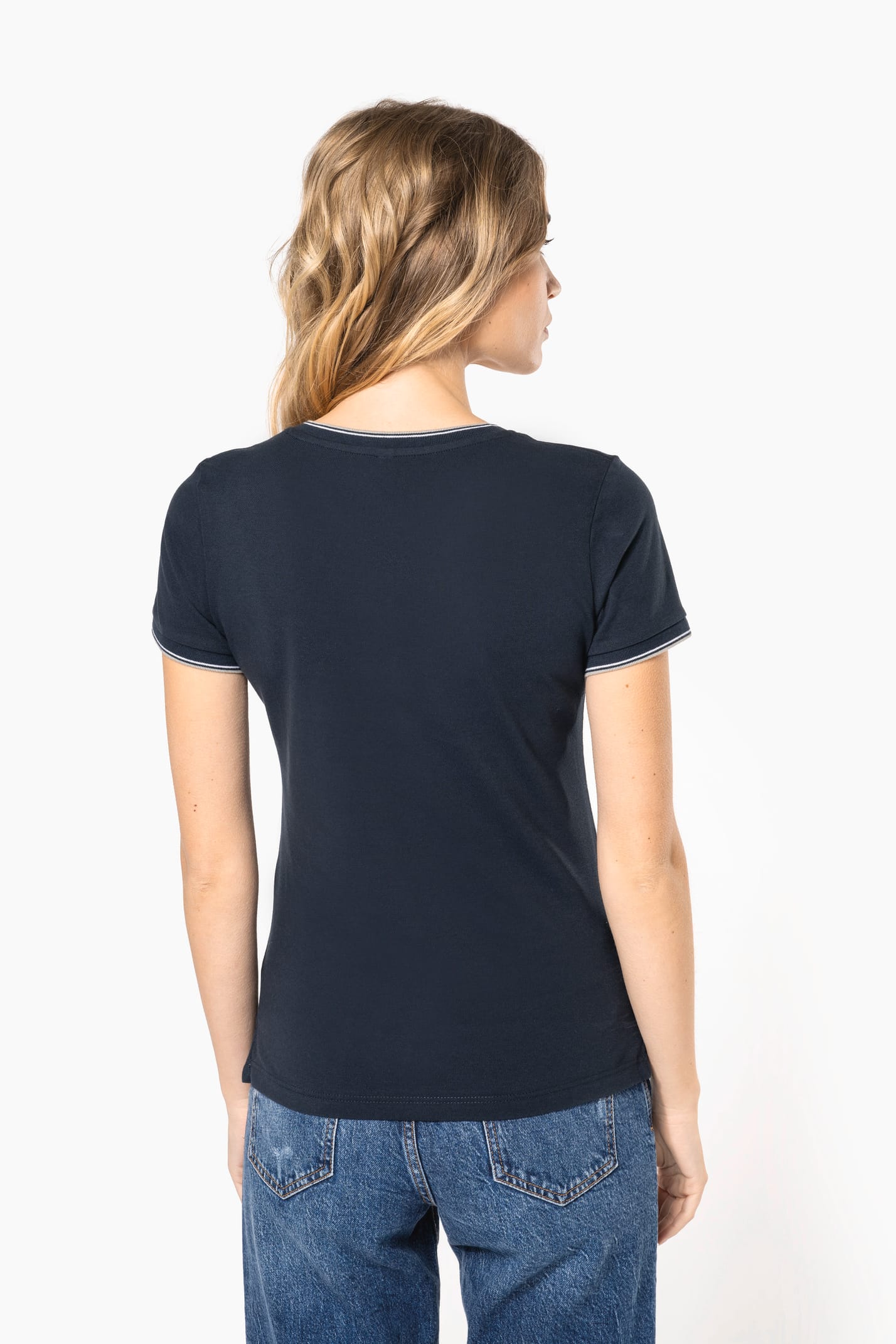 Femme blonde cheveux longs qui porte un T-shirt maille piquée col V Navy.