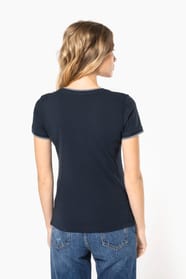 Femme blonde cheveux longs qui porte un T-shirt maille piquée col V Navy.