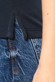 Femme blonde cheveux longs qui porte un T-shirt maille piquée col V Navy.