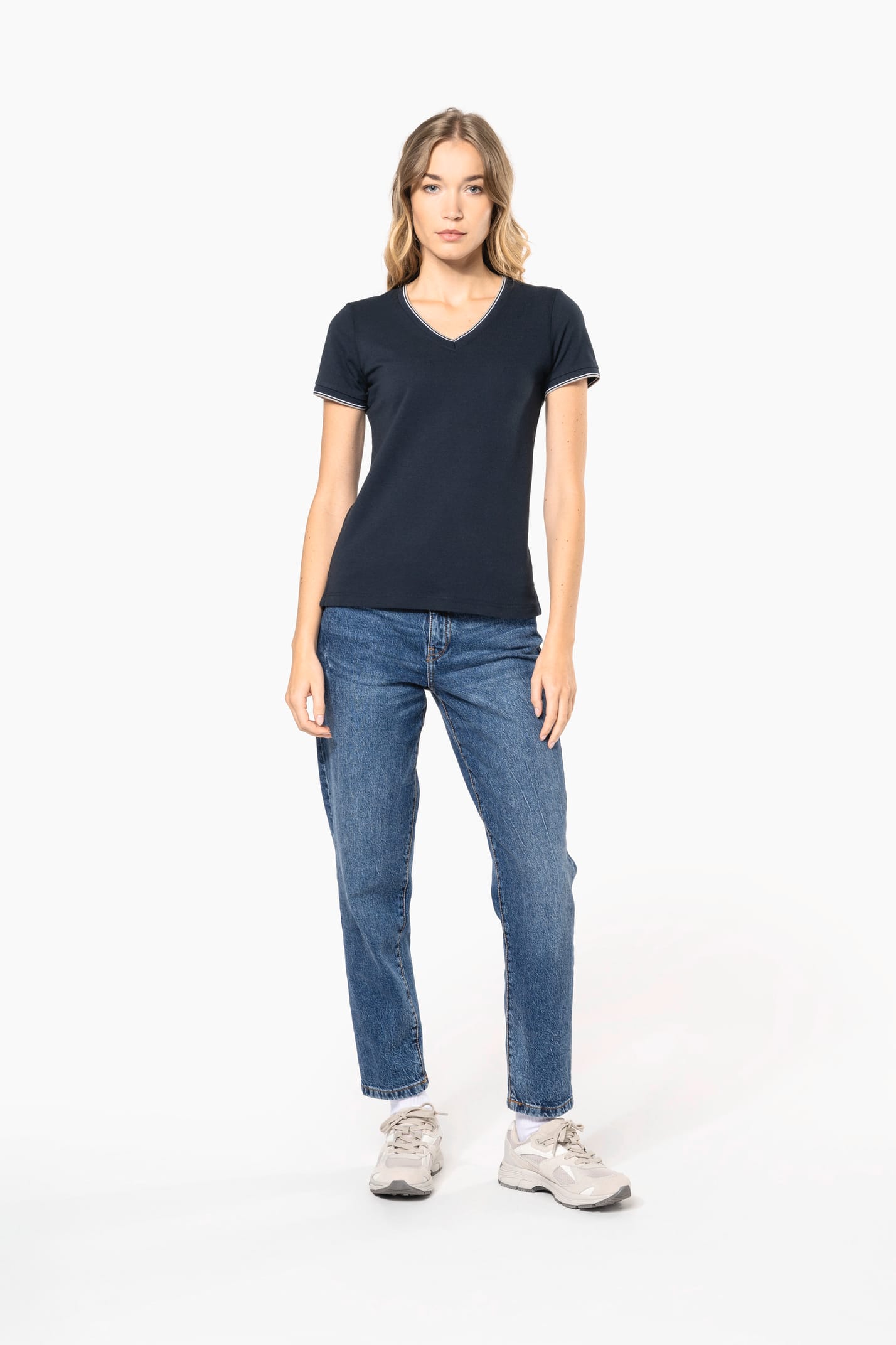 Femme blonde cheveux longs qui porte un T-shirt maille piquée col V Navy.