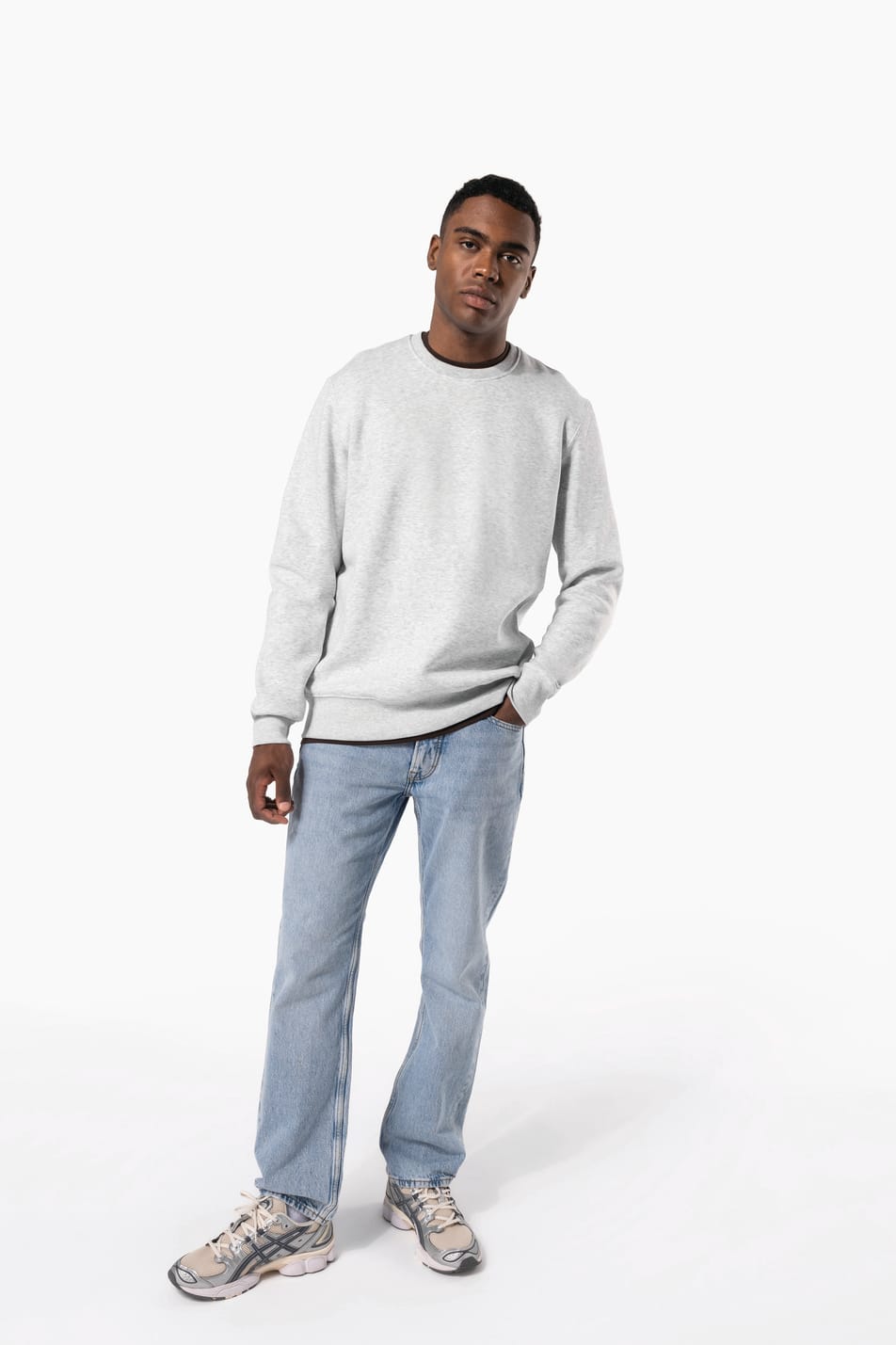 Homme brun cheveux courts qui porte un sweat clair chiné.