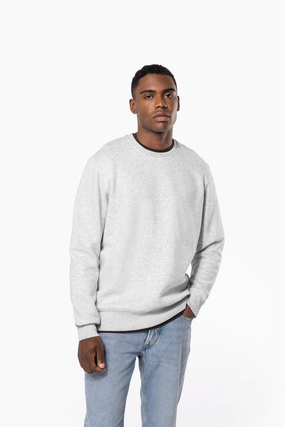 Homme brun cheveux courts qui porte un sweat clair chiné.