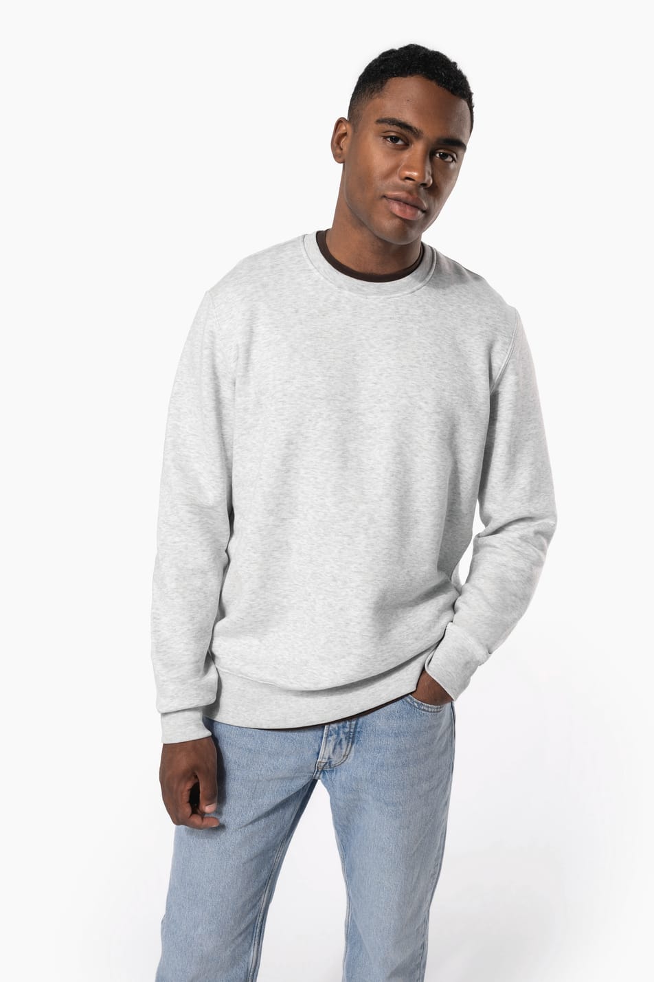 Homme brun cheveux courts qui porte un sweat clair chiné.