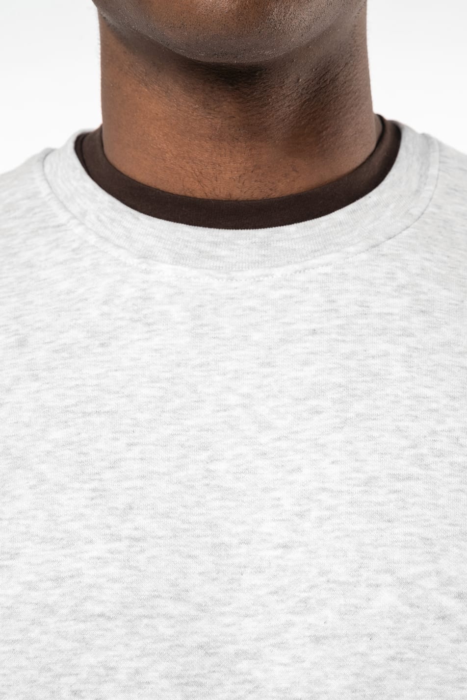 Homme brun cheveux courts qui porte un sweat clair chiné.