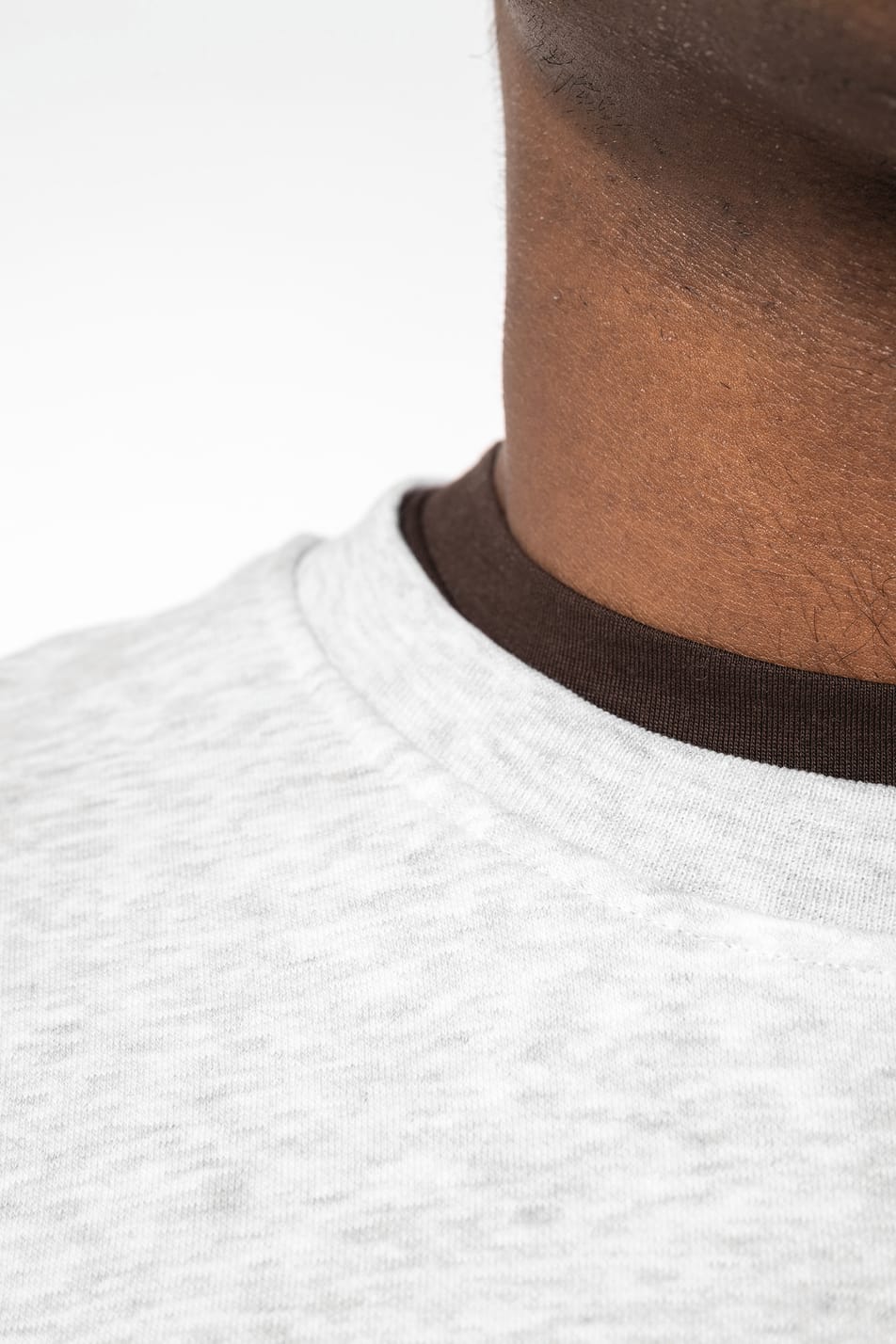 Homme brun cheveux courts qui porte un sweat clair chiné.