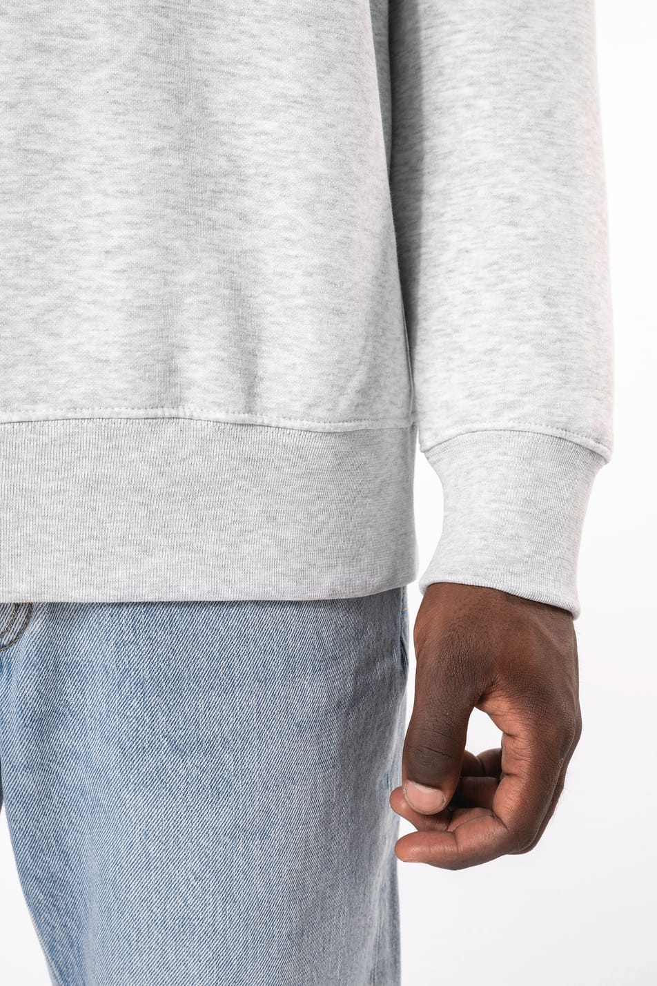 Homme brun cheveux courts qui porte un sweat clair chiné.