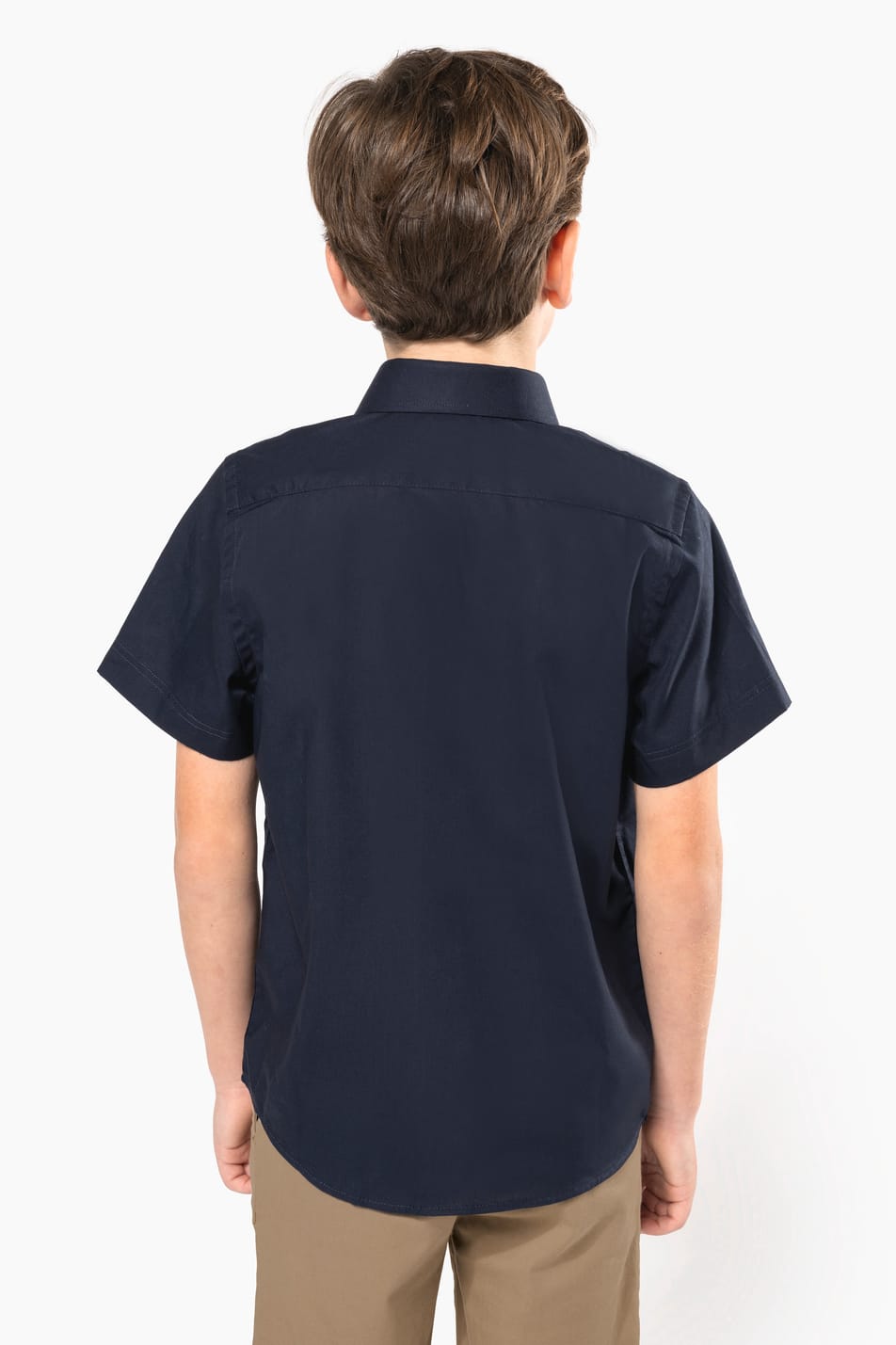 Jeune garçon cheveux courts châtain qui porte une chemise popeline manches courtes Navy.
