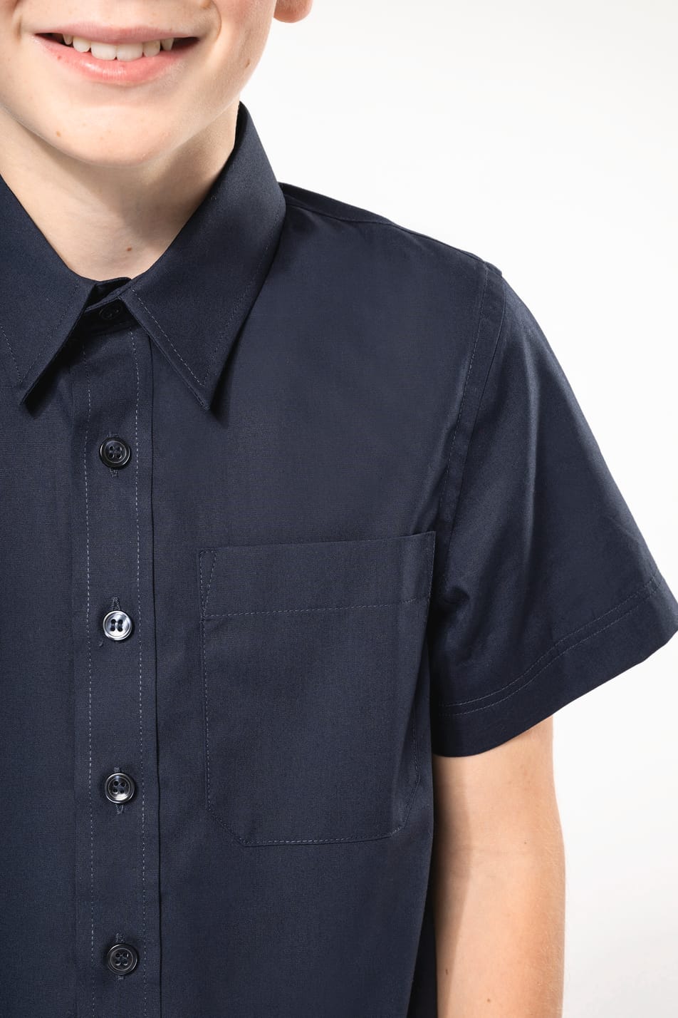 Jeune garçon cheveux courts châtain qui porte une chemise popeline manches courtes Navy.