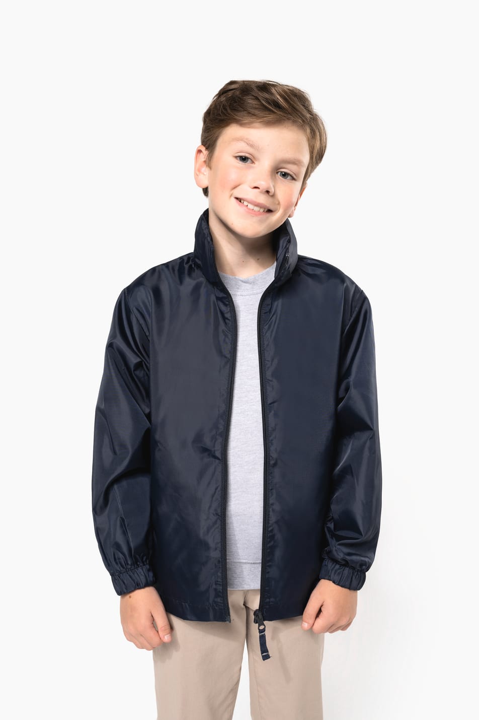 Jeune garçon cheveux courts châtain qui porte un coupe-vent non doublé Navy.