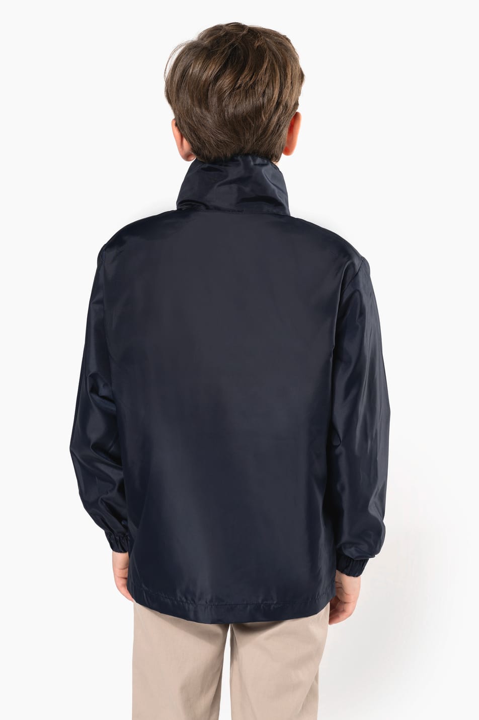Jeune garçon cheveux courts châtain qui porte un coupe-vent non doublé Navy.