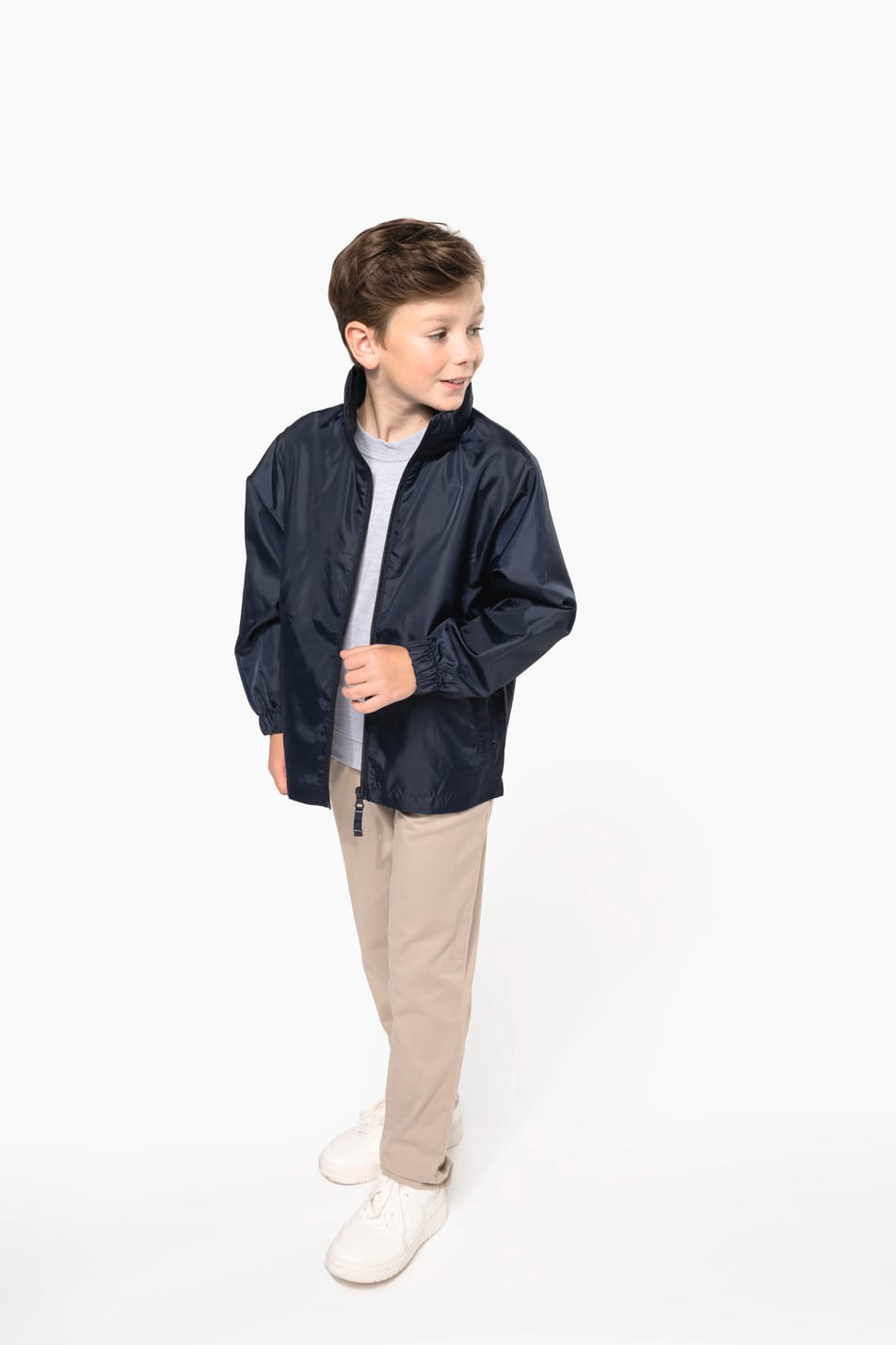 Jeune garçon cheveux courts châtain qui porte un coupe-vent non doublé Navy.