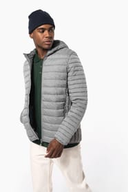 Homme brun avec un bonnet noir qui porte une doudoune légère à capuche argentée.