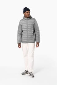 Homme brun avec un bonnet noir qui porte une doudoune légère à capuche argentée.