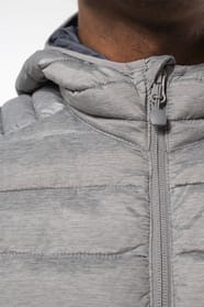 Homme brun avec un bonnet noir qui porte une doudoune légère à capuche argentée.