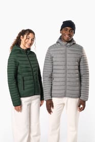 Femme aux cheveux frisls attachés et homme brun avec bonnet noir qui portent des doudounes légères à capuches vert forêt et argenté.