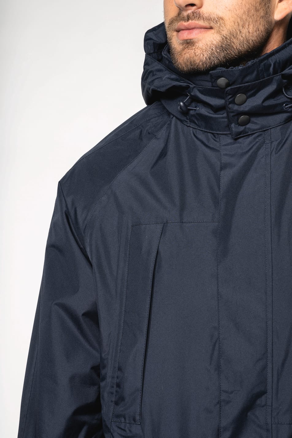 Homme brun rasé qui porte une parka 3 en 1 Navy.