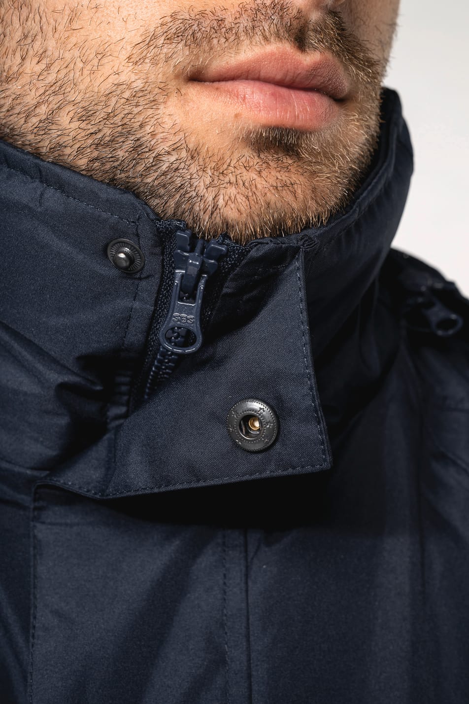 Homme brun rasé qui porte une parka 3 en 1 Navy.