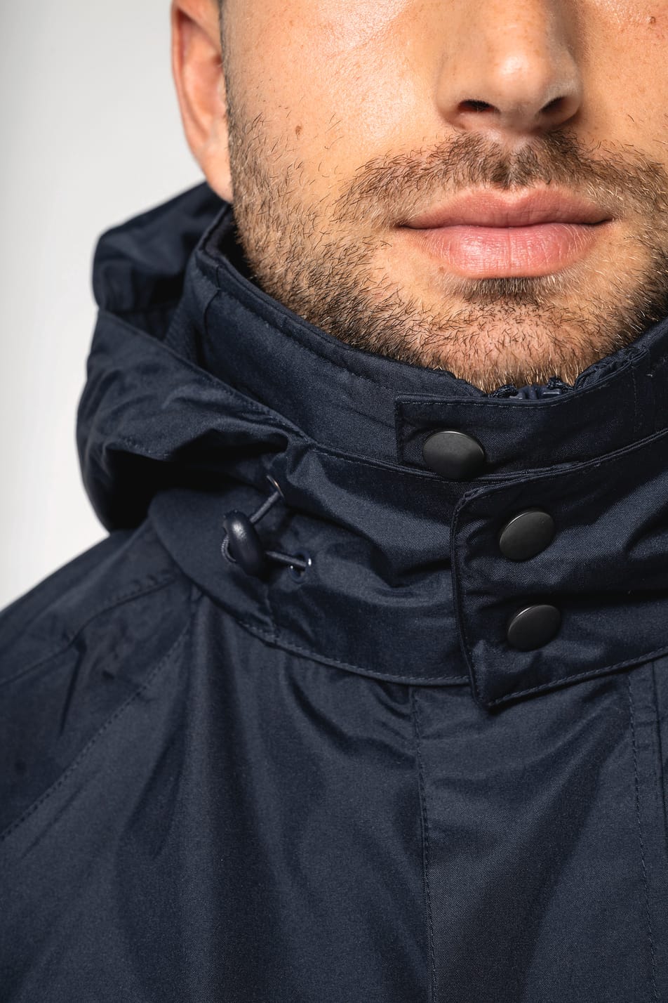 Homme brun rasé qui porte une parka 3 en 1 Navy.