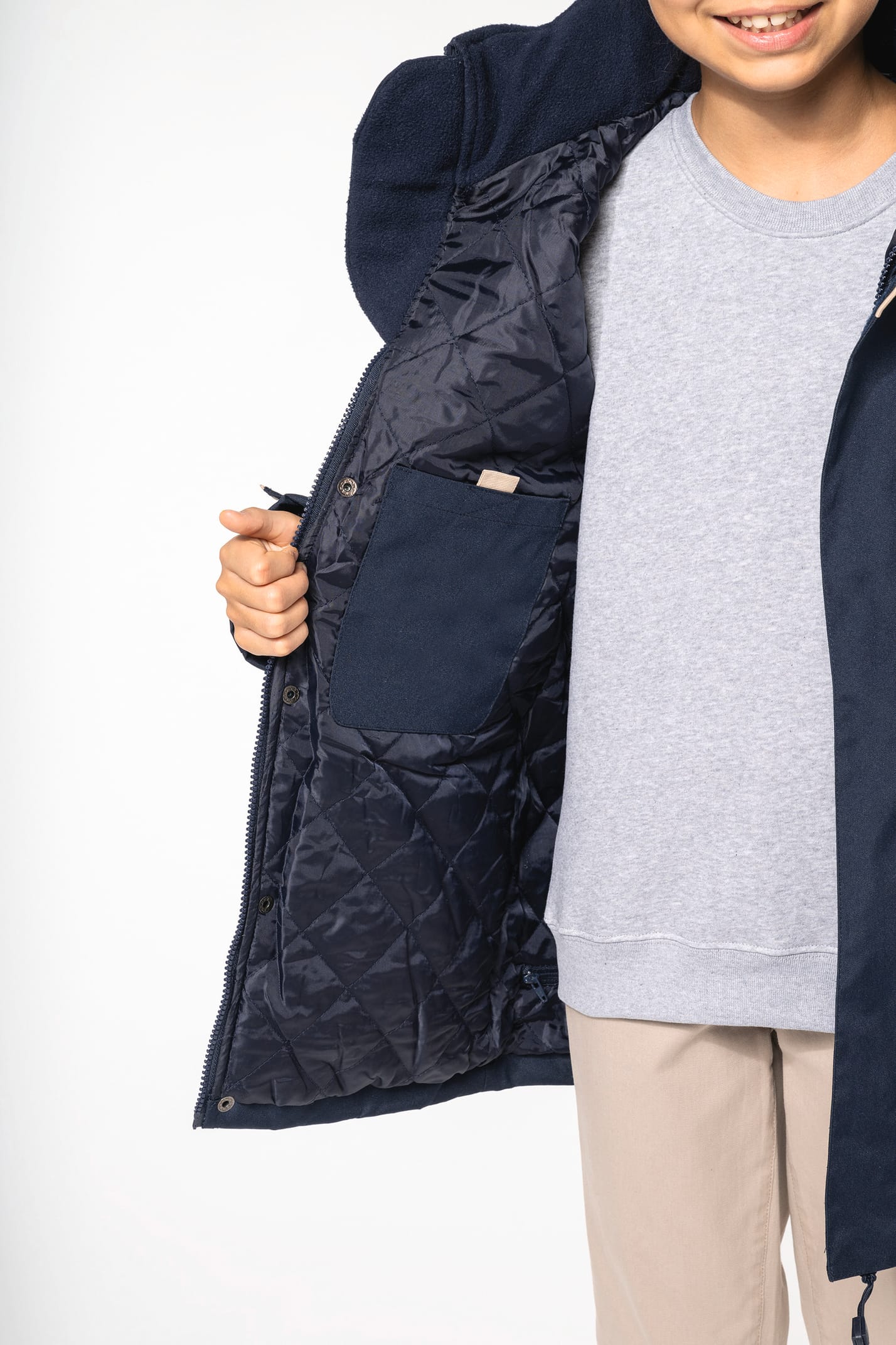 Jeune fille brune cheveux attachés qui porte une parka Navy.