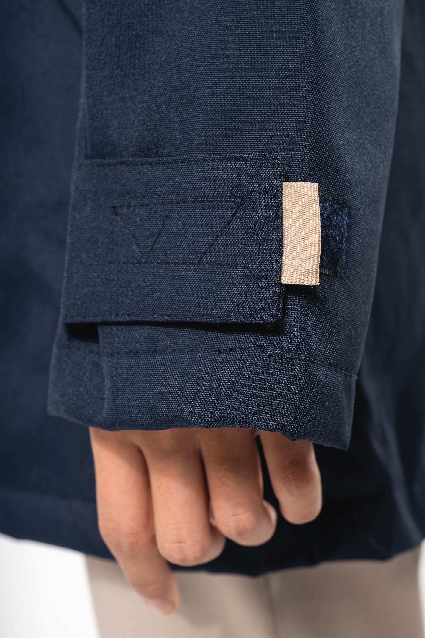 Jeune fille brune cheveux attachés qui porte une parka Navy.