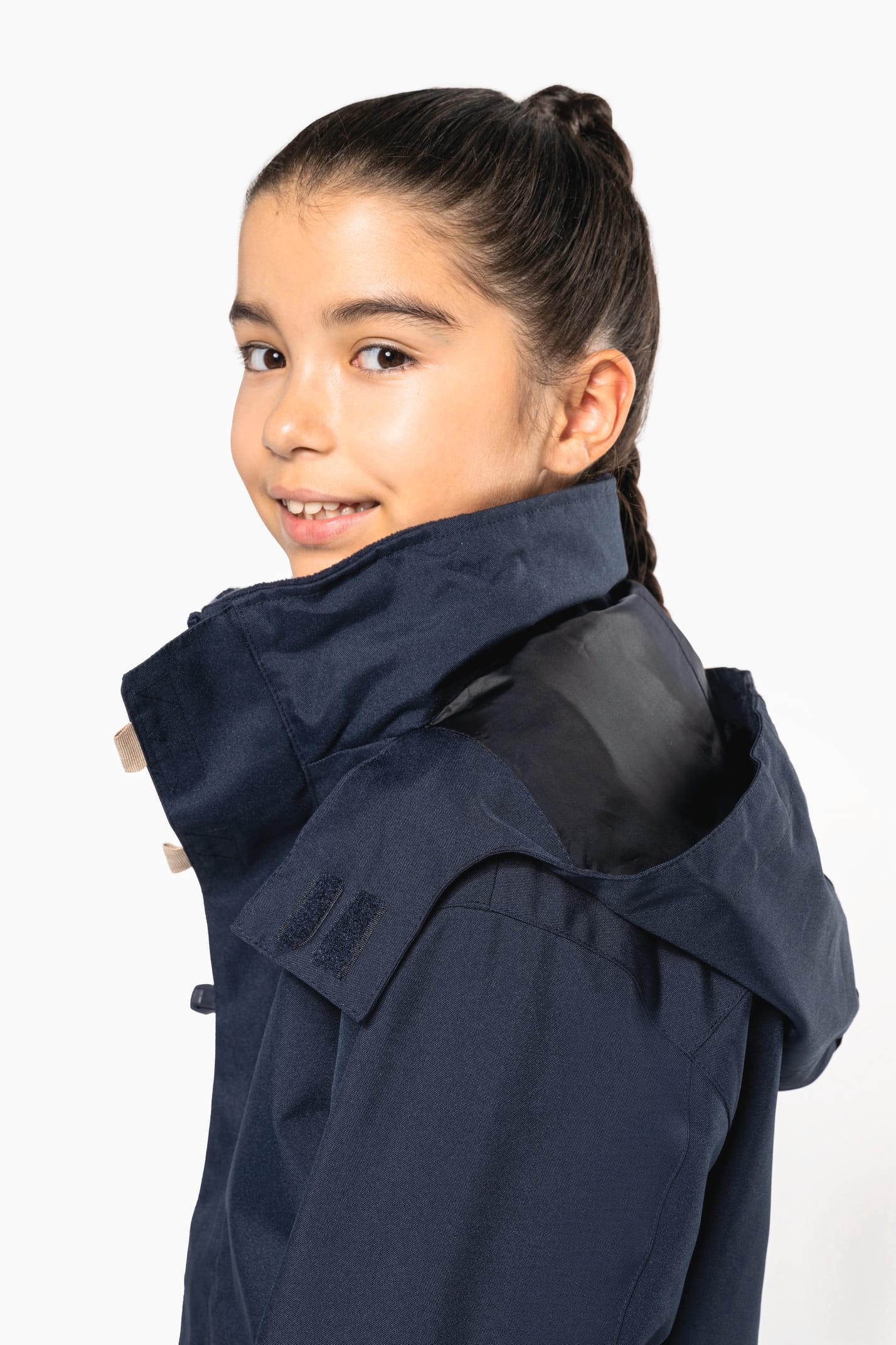 Jeune fille brune cheveux attachés qui porte une parka Navy.