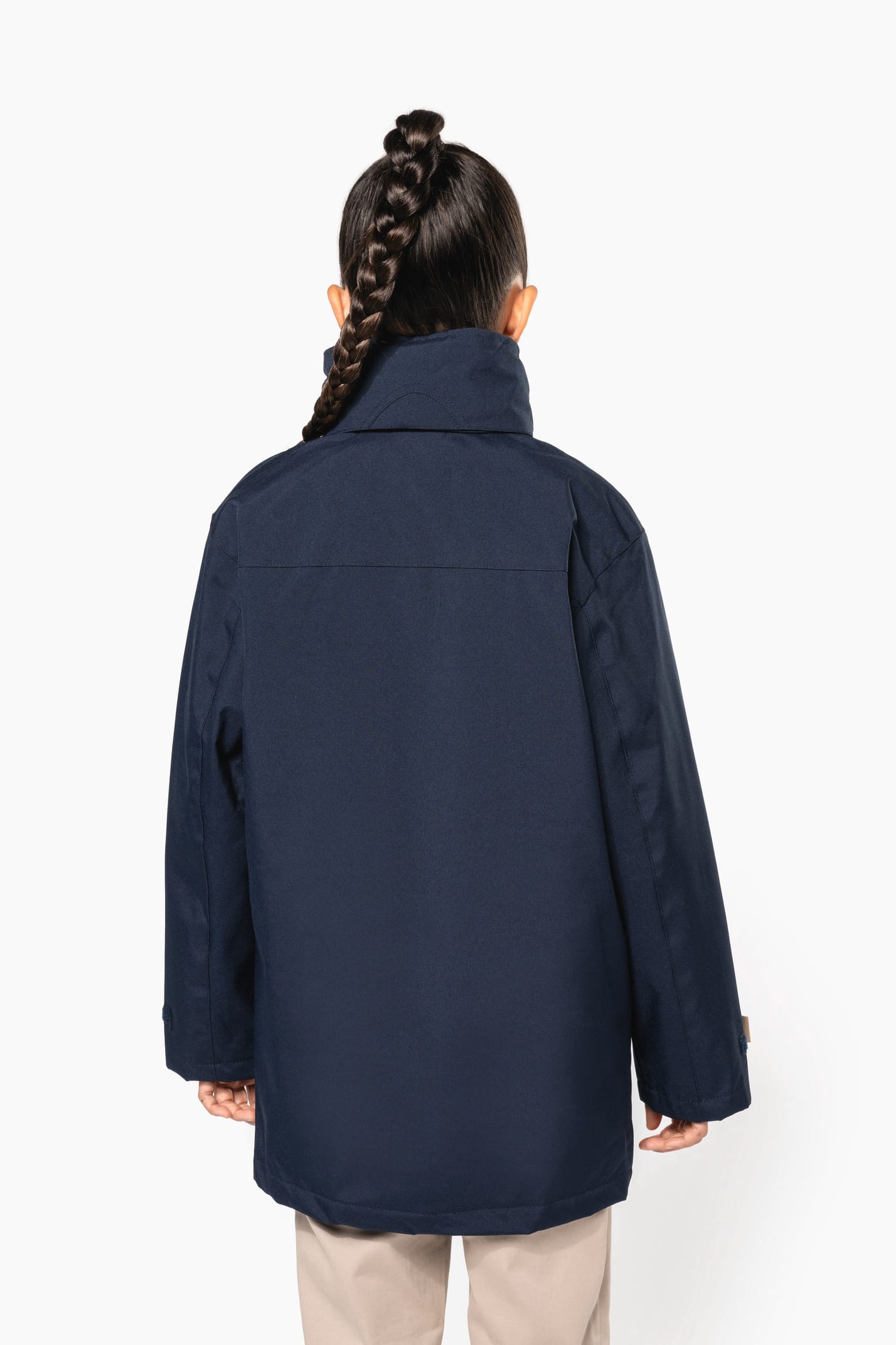 Jeune fille brune cheveux attachés qui porte une parka Navy.