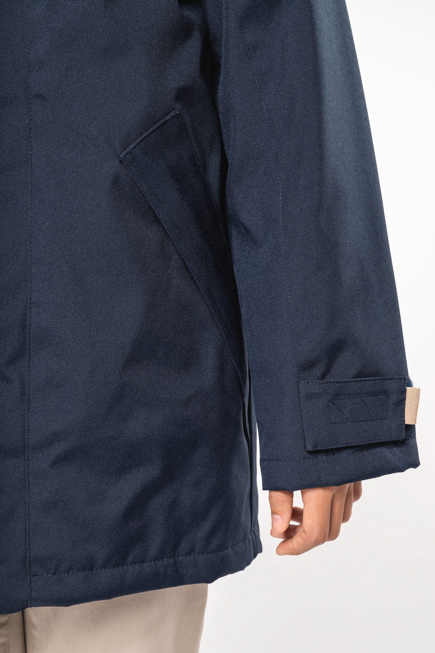 Jeune fille brune cheveux attachés qui porte une parka Navy.