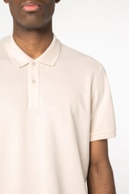 Détail épaule d'un polo blanc cassé porté par un homme