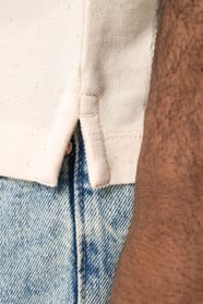 Détail du coté d'un polo blanc cassé porté par un homme