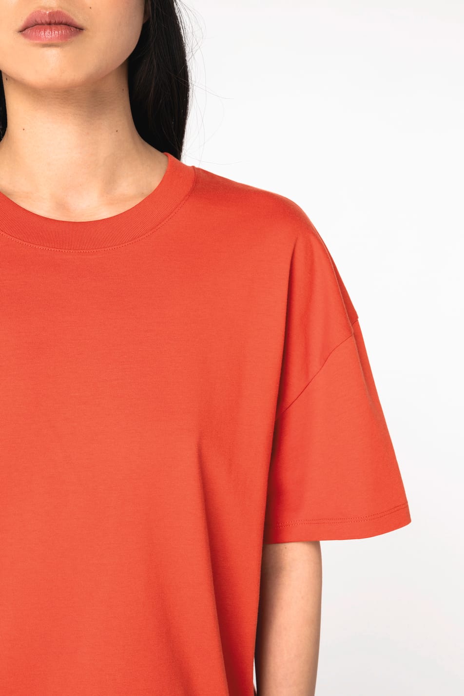 Détail épaule d'un t-shirt oversize rouge porté par une femme