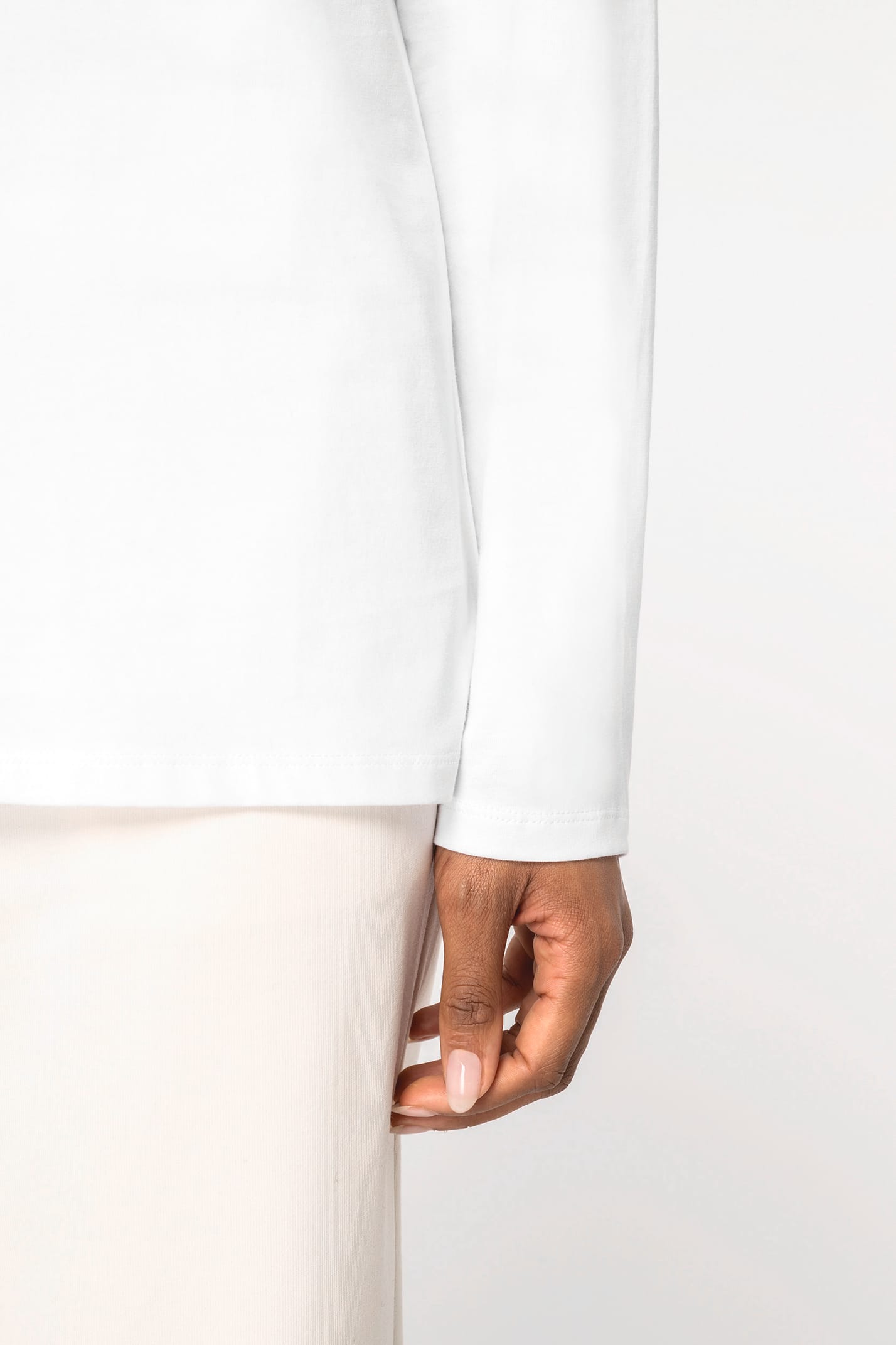 Détail d'une manche d'un t-shirt blanc à manches longues porté par une femme