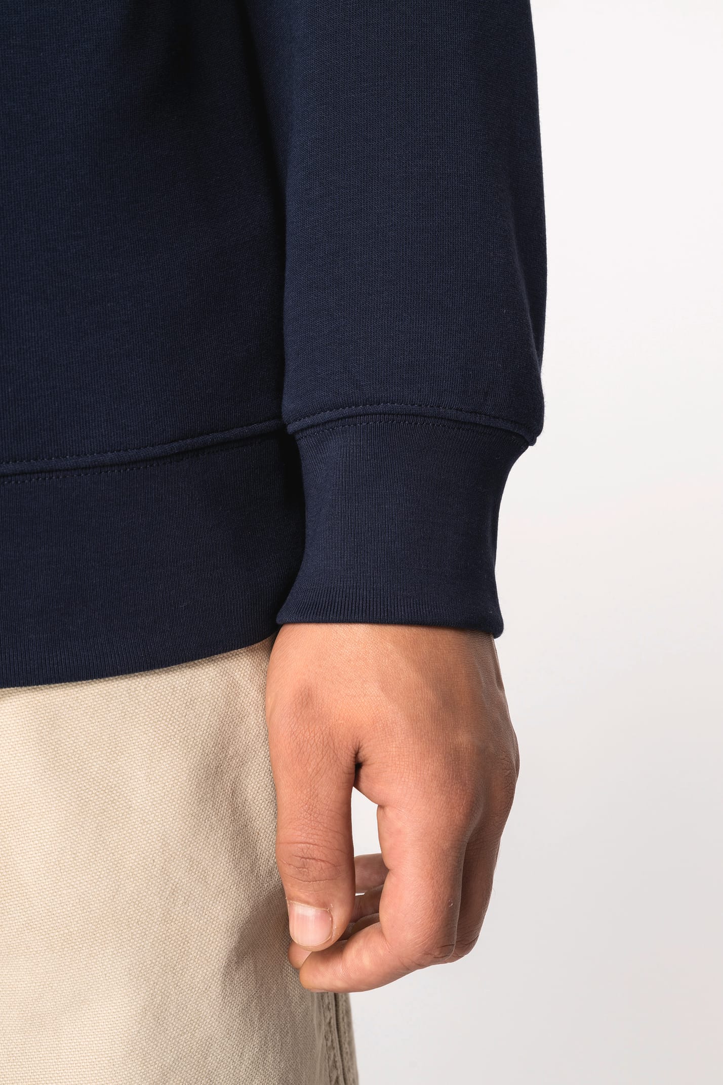Détail manche d'un sweat-shirt bleu foncé porté par un homme