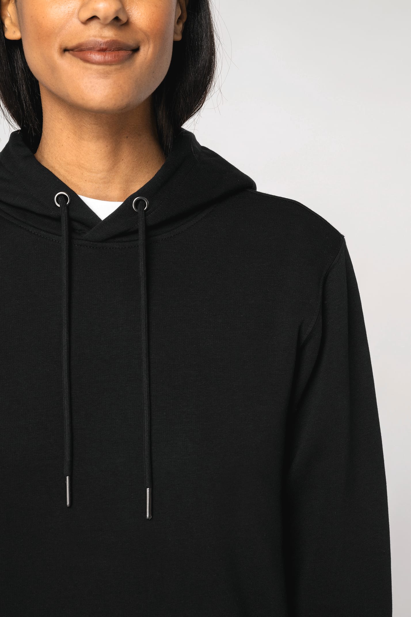 Détail épaule d'un sweat-shirt à capuche noir porté par une femme