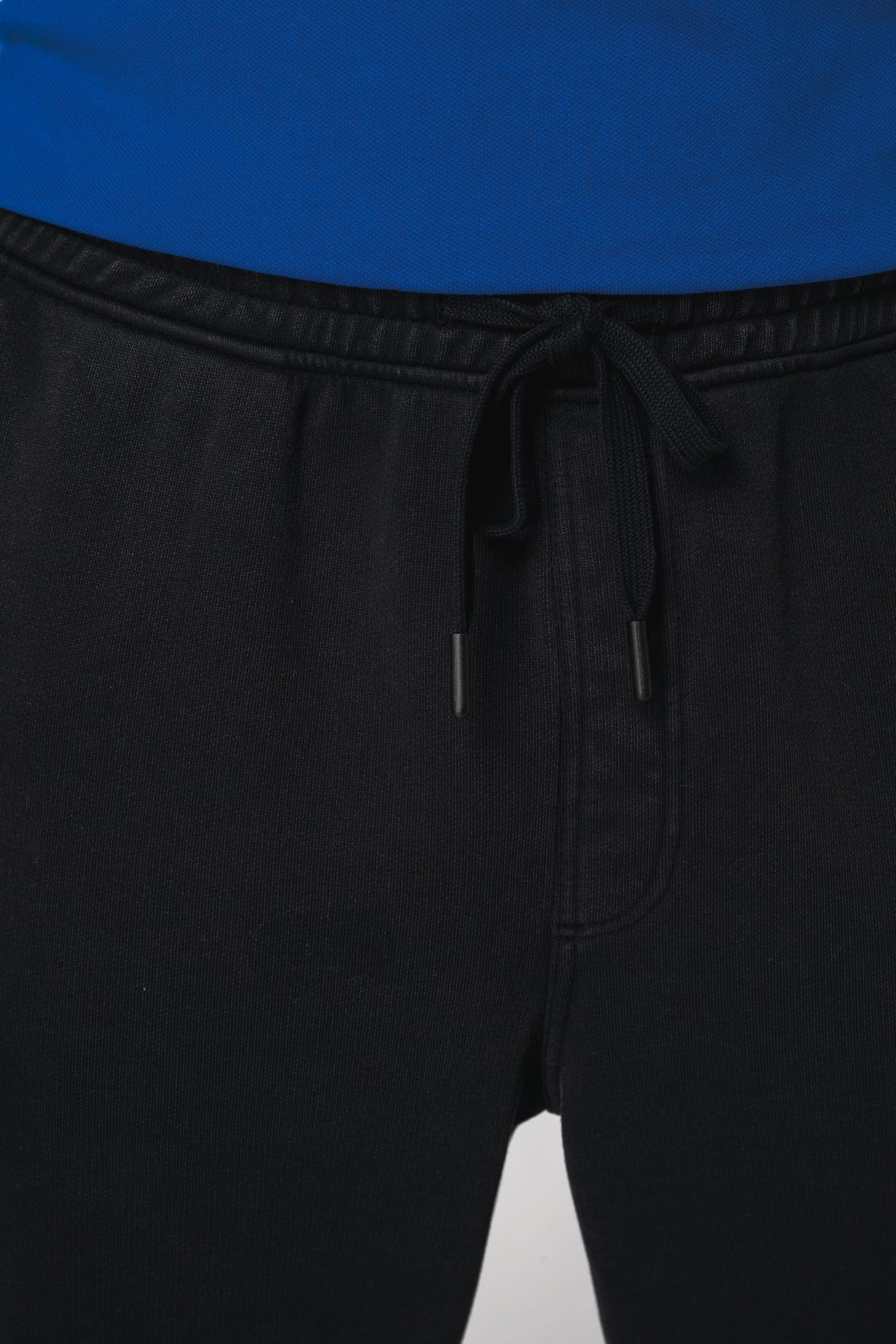 Détail d'un pantalon noir porté par un homme