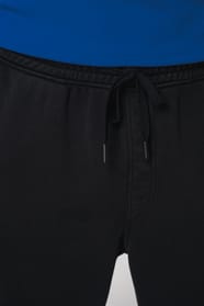 Détail d'un pantalon noir porté par un homme