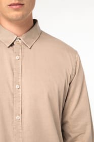 Détail d'une chemise beige portée par un homme