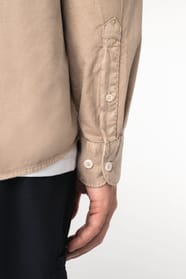 Détail d'une chemise beige portée par un homme