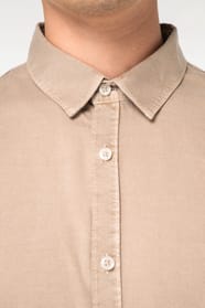 Détail d'une chemise beige portée par un homme