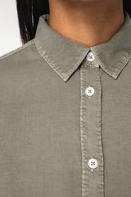 Détail d'une chemise kaki portée par une femme