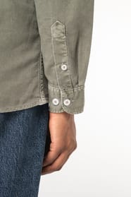 Détail d'une chemise kaki portée par une femme